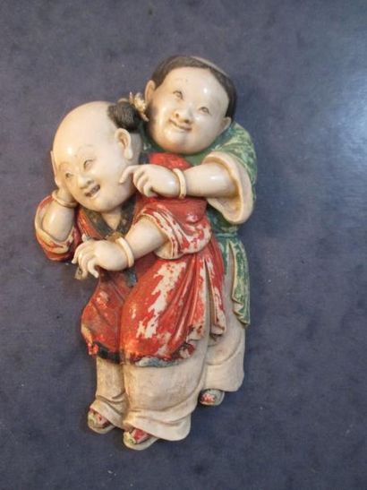 null Bas relief en ivoire polychrome représentant deux enfants. Chine fin XIXème...