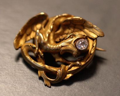 null Broche en or jaune 18k en forme de dragon tenant dans sa gueule un diamant taille...