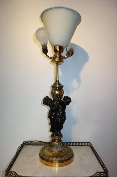 null Pied de lampe en bronze doré et patiné à décor de putti

H : 65 cm.