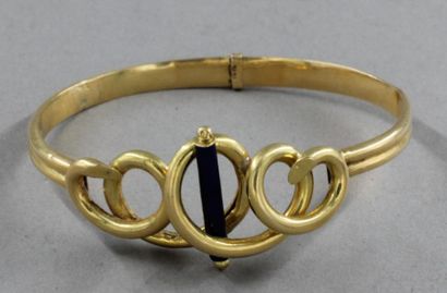 null Bracelet rigide en or jaune 18k creux à décor de volutes et d'un baton émaillé...