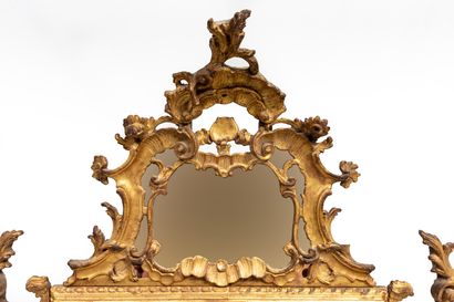 null A carved and gilded wooden mirror, decorated with flowers and shells.

Italian...