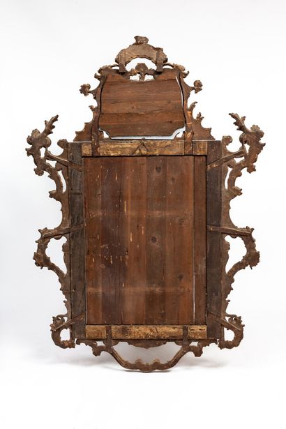 null A carved and gilded wooden mirror, decorated with flowers and shells.

Italian...