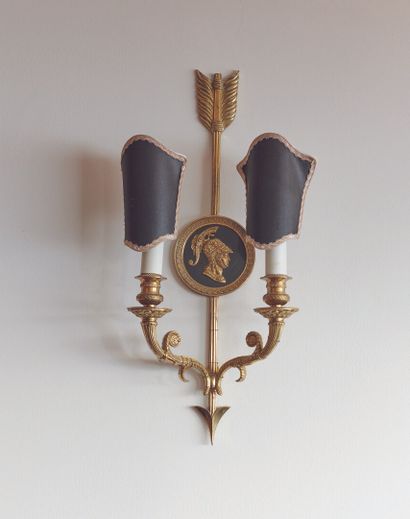 null 
A set of three two-light sconces in patinated and gilt bronze, decorated with...