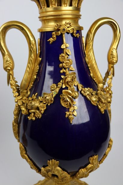 null A pair of deep blue enamelled porcelain and gilt bronze covered vases with swan...