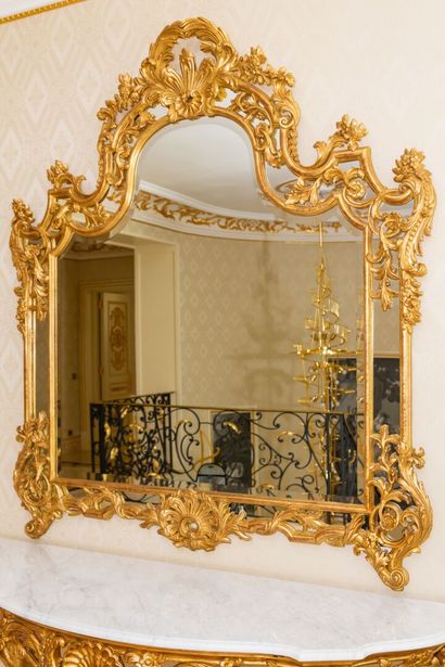 null Large miroir à parecloses en bois sculpté et doré à décor de coquilles et feuillages....