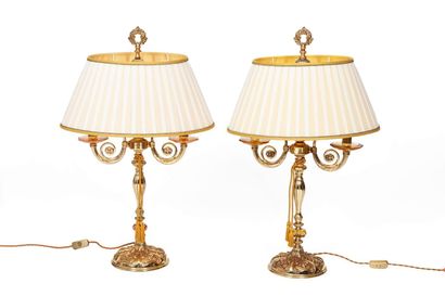 null Pair of gilded metal lamps with two light arms and shades in pleated fabric.

The...