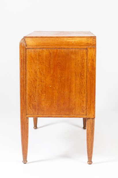 null Oak chest of drawers with fluted uprights.

The central door decorated with...