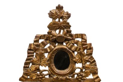 null Small mirror with parecloses out of carved and gilded wood, the pediment decorated...