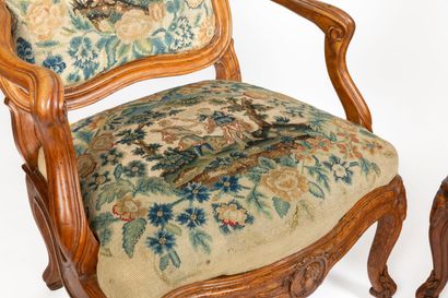null Pair of flat-backed armchairs in molded and carved wood, the belt decorated...