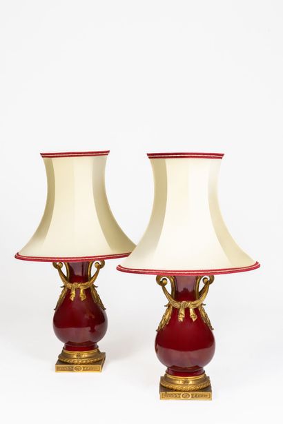 null A pair of large red enameled porcelain baluster lamps with gilt bronze mounts...