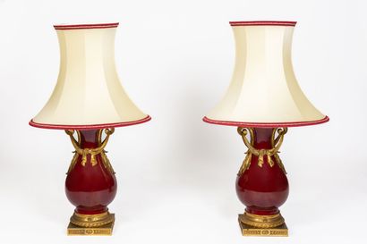 null A pair of large red enameled porcelain baluster lamps with gilt bronze mounts...