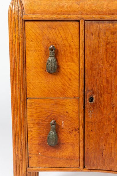 null Oak chest of drawers with fluted uprights.

The central door decorated with...