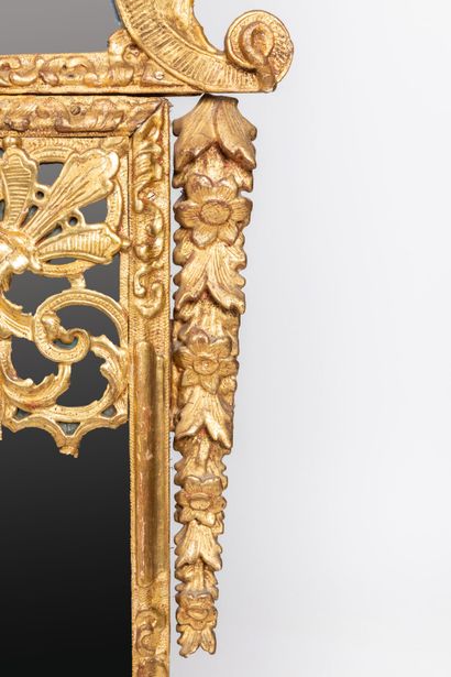 null Important miroir à fronton et parecloses en bois sculpté et doré à décor de...