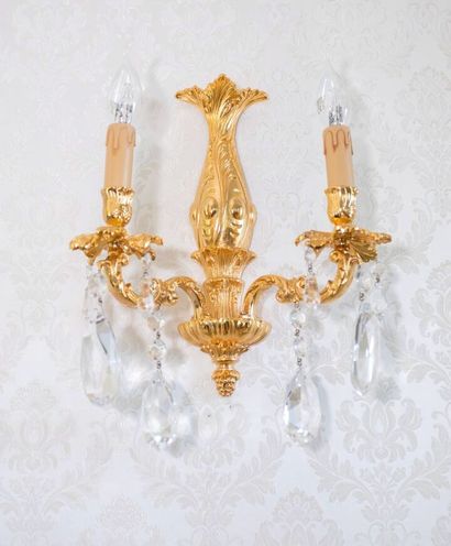 null Suite of eight two-light gilt bronze sconces.

Louis XV style.

H_34 cm L_31...