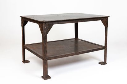 null Industrial table in beaten metal with a patina, with large metal rivets.
The...