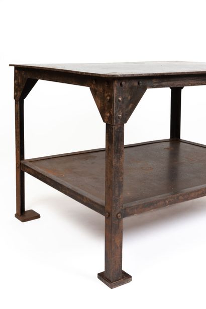 null Industrial table in beaten metal with a patina, with large metal rivets.
The...