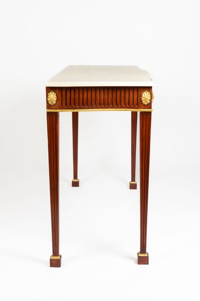 null Pair of mahogany and gilded wood consoles with belt and fluted legs. 
Polished...