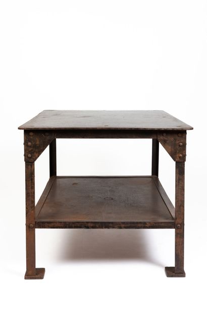 null Industrial table in beaten metal with a patina, with large metal rivets.
The...