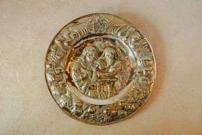 null Large circular dish in repoussé brass depicting a tavern scene. 
Bears a coat...