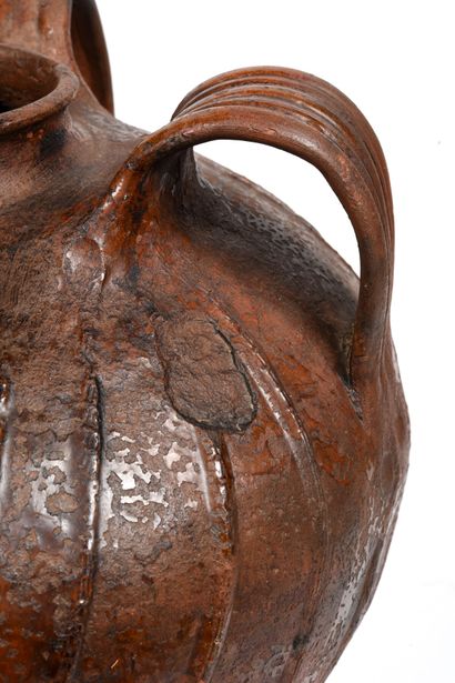 null Terracotta oil jug with brown glaze.
The body has sloping ribs.
Three handles...