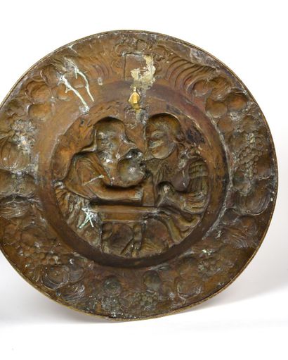 null Large circular dish in repoussé brass depicting a tavern scene. 
Bears a coat...