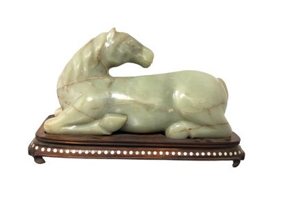 null CHINE - XXe siècle
Cheval couché en jade (néphrite) céladon sculpté, la tête...