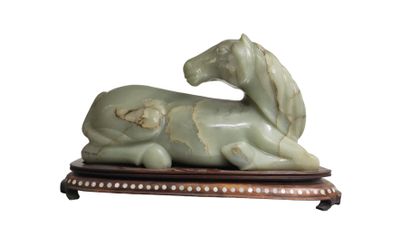 null CHINE - XXe siècle
Cheval couché en jade (néphrite) céladon sculpté, la tête...