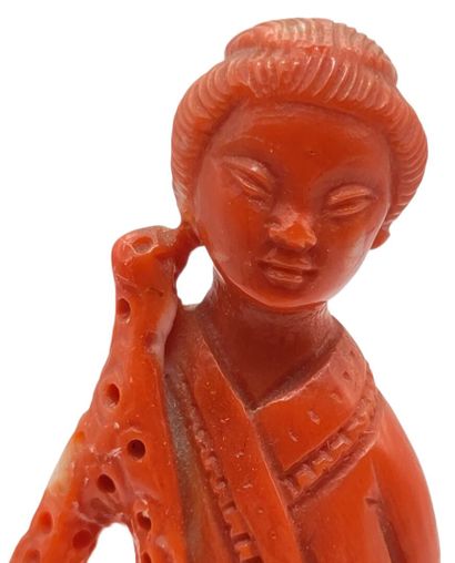 null CHINE - XXe siècle
Statuette de jeune femme debout en corail rouge tenant une...