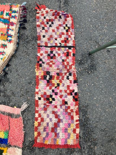 null Trois tapis : 
Un fond rose à motifs géométriques polychromes. 
148 x 88 cm....