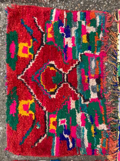 null Quatre tapis : 
Un fond rouge à motifs verts roses et bleus. 
82 x 57 cm. 
Un...