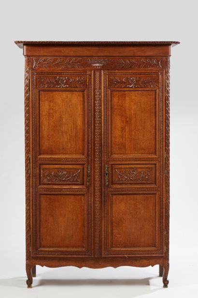 null Armoire en bois naturel mouluré et sculpté de bouquets et guirlandes, frises...