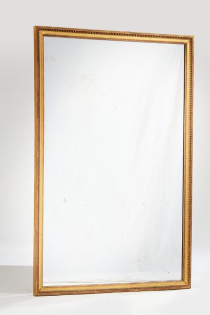 null Miroir de forme rectangulaire en bois et stuc dorés à décor d'un frise de perles...