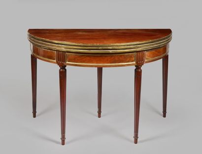 null A mahogany and mahogany veneer half-moon table with tapered and fluted legs...
