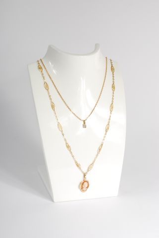 null * Lot in 18K yellow gold 750/000 comprising two chains and pendants, one with...