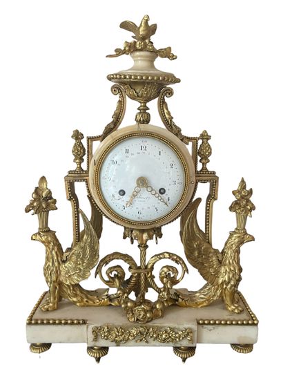 null * Portico clock in gilt bronze and white marble decorated with two winged sphinxes...