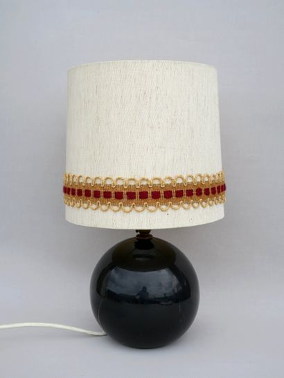 null A black ceramic table lamp with beige fabric shade, made in France, circa 1960...
