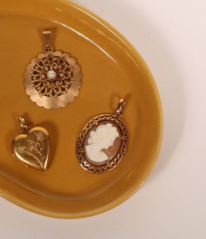 null Lot comprenant :
Pendentif en or jaune 18K 750‰, de forme ovale, ajouré, paré...