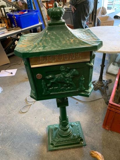 null LETTER BOX on green painted cast iron base, in the shape of a house with trophies...