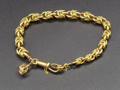 null BRACELET in 18K yellow gold (750 thousandths) with interlaced mesh decorated...