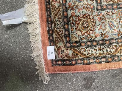 null Silk carpet with polychrome floral decoration on a red background.

Bears a...