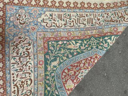 null Silk prayer rug with polychrome decoration of floral motifs and inscriptions....