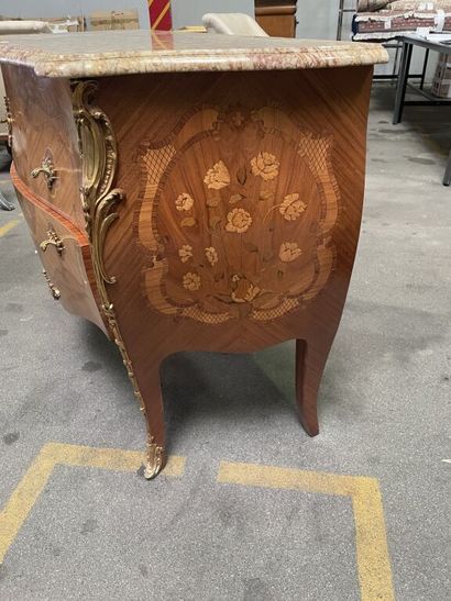 null An inlaid and frizzled veneer chest of drawers decorated on three sides with...