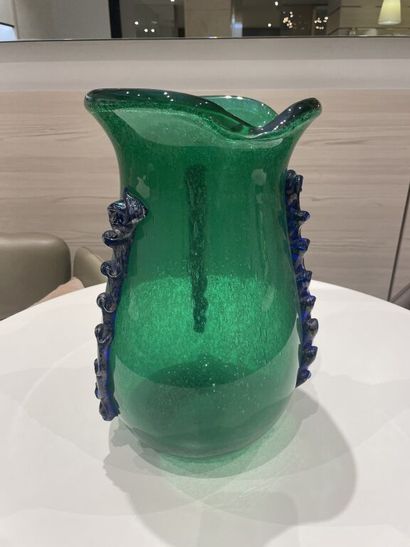 null WORK OF THE XXth century

A large green glass vase with a flared neck decorated...