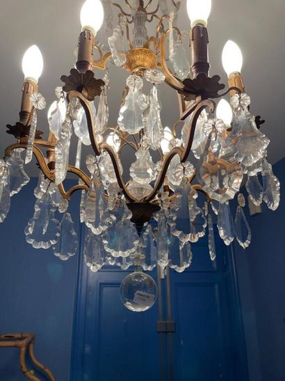 null Chandelier with eight arms of light out of gilded metal and crystal with decoration...