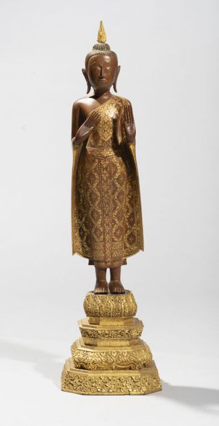  THAILANDE. 
Statue de bouddha en bois partiellement doré, représenté debout sur...