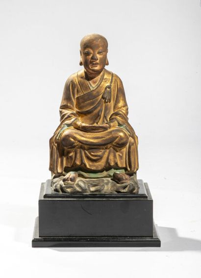 null CHINA.

Statuette of luohan in gilded and polychrome stucco, represented seated...