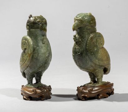  CHINE. 
Paire d'oiseaux archaïsant en jade brun vert nuancé à décor sculpté de masques...