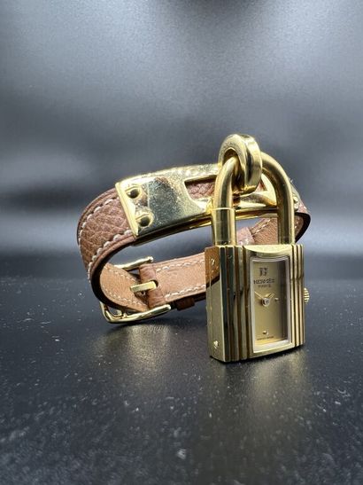  HERMÈS, Paris. Modèle Kelly. 
MONTRE BRACELET de dame en métal plaqué or, composée...