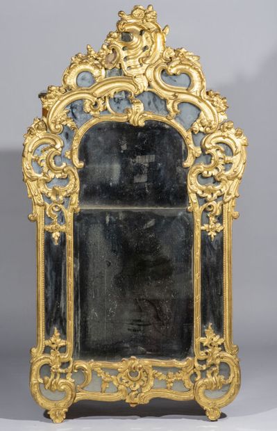  Important carved and gilded wood mirror with openwork decoration of volutes, leathers...