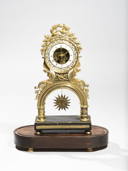 null Skeleton clock in chased and gilded bronze, topped by a pair of birds pecking...
